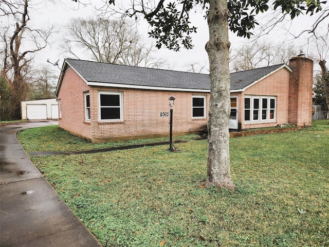 view of front of property with an outbuilding, a front yard, and a garage