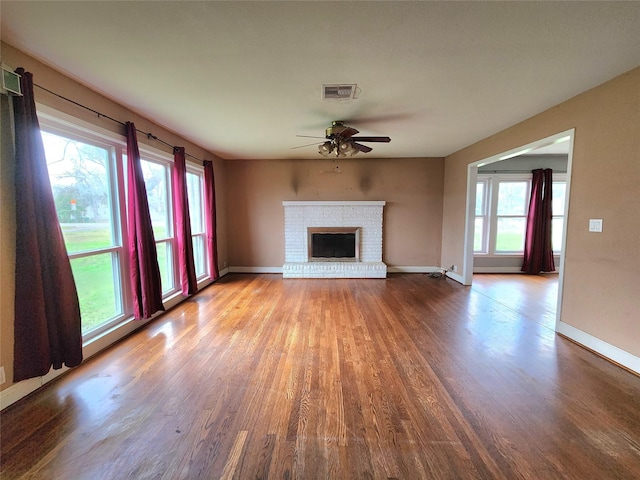 unfurnished living room with a brick fireplace, ceiling fan, and light hardwood / wood-style flooring