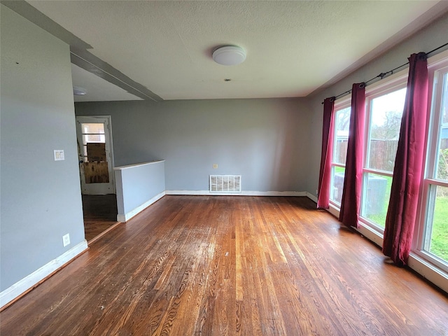 spare room with wood-type flooring and a textured ceiling