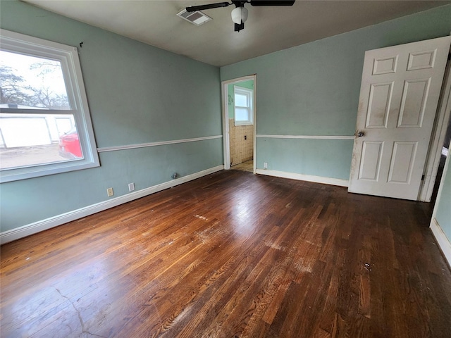 empty room with ceiling fan and dark wood-type flooring