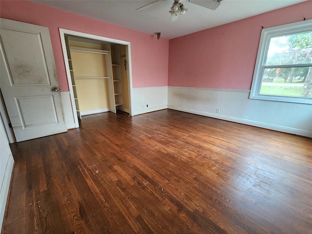 unfurnished bedroom with ceiling fan, a closet, and dark wood-type flooring