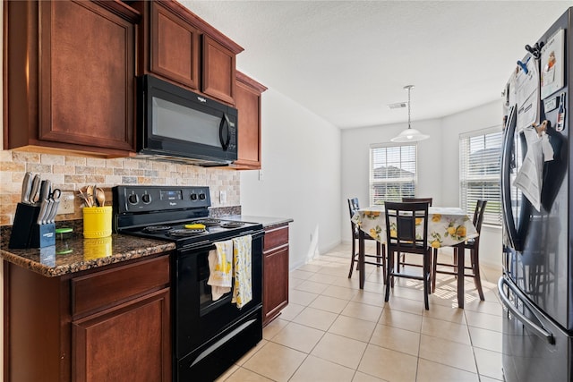 kitchen featuring dark stone countertops, black appliances, light tile patterned flooring, decorative backsplash, and decorative light fixtures