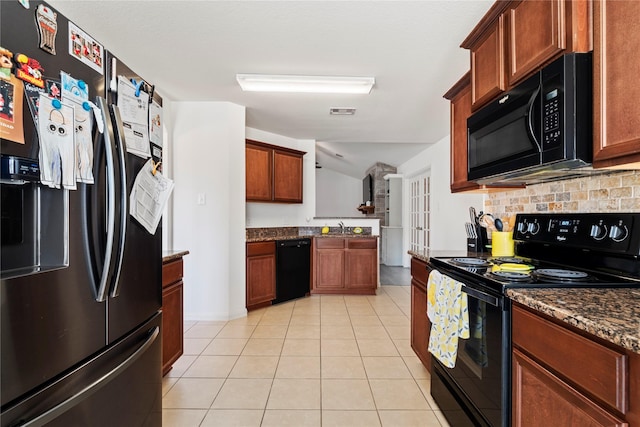 kitchen with sink, black appliances, dark stone countertops, light tile patterned floors, and backsplash