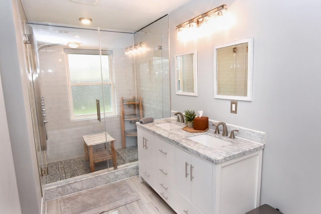 full bathroom featuring a stall shower, a sink, and double vanity