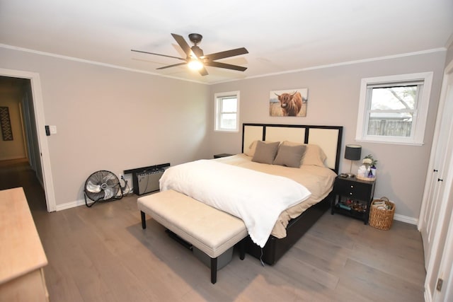 bedroom with ceiling fan, crown molding, baseboards, and wood finished floors