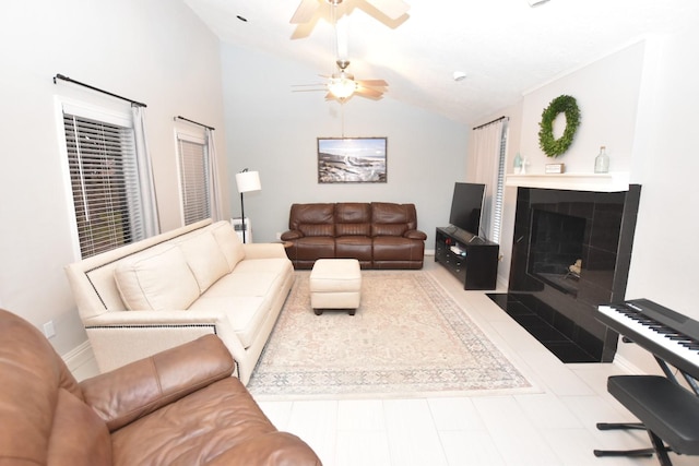 living area with lofted ceiling, ceiling fan, a fireplace, and baseboards