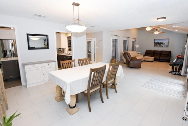 dining space featuring visible vents, vaulted ceiling, and ceiling fan