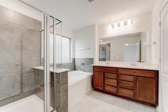 bathroom with shower with separate bathtub, a textured ceiling, vanity, and tile patterned floors