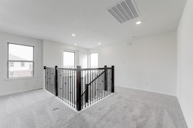 hallway featuring carpet floors and a textured ceiling