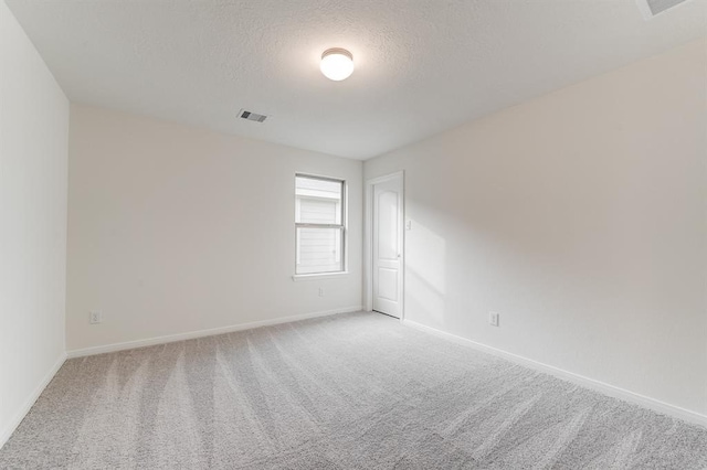 empty room with a textured ceiling and carpet