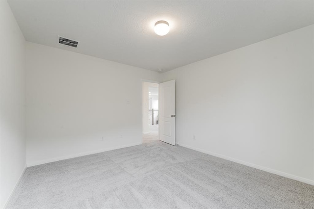 carpeted spare room featuring a textured ceiling