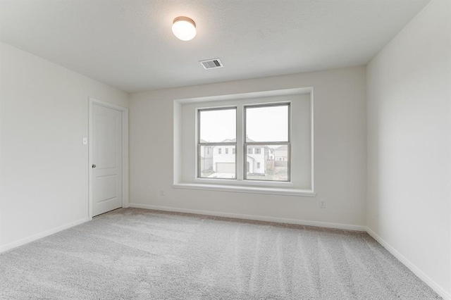 carpeted empty room featuring a textured ceiling