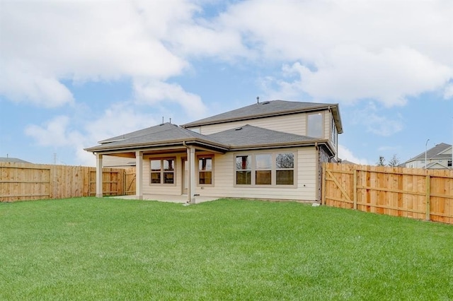 rear view of property featuring a patio area and a lawn