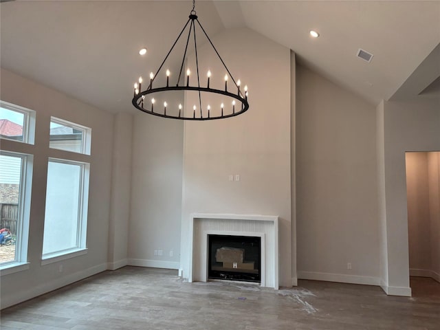 6104 T St, Katy, TX 77493 - unfurnished living room featuring a chandelier, high vaulted ceiling, baseboards, wood finished floors, and a fireplace with flush hearth