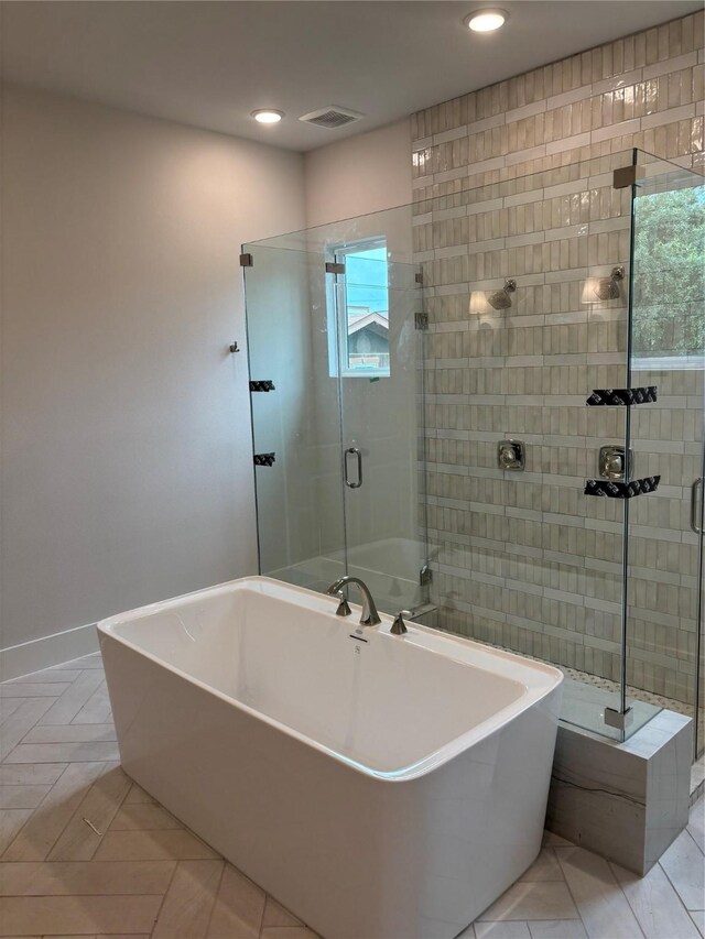 6104 T St, Katy, TX 77493 - bathroom featuring a shower stall, a soaking tub, recessed lighting, tile patterned flooring, and baseboards