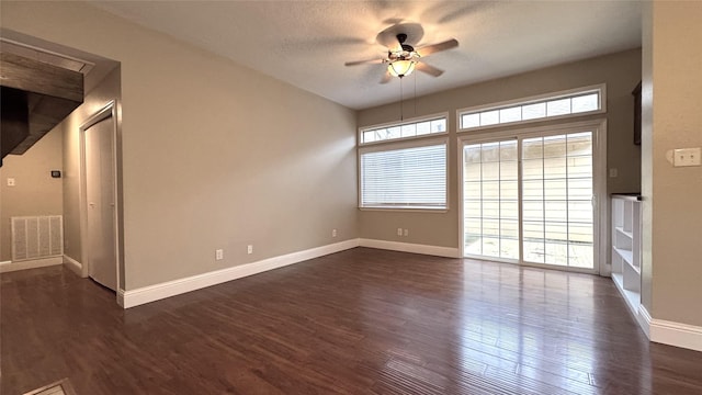 empty room with dark hardwood / wood-style floors, a textured ceiling, and ceiling fan