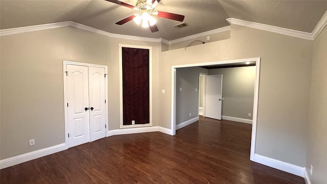 unfurnished room with vaulted ceiling, ornamental molding, dark wood-type flooring, and ceiling fan