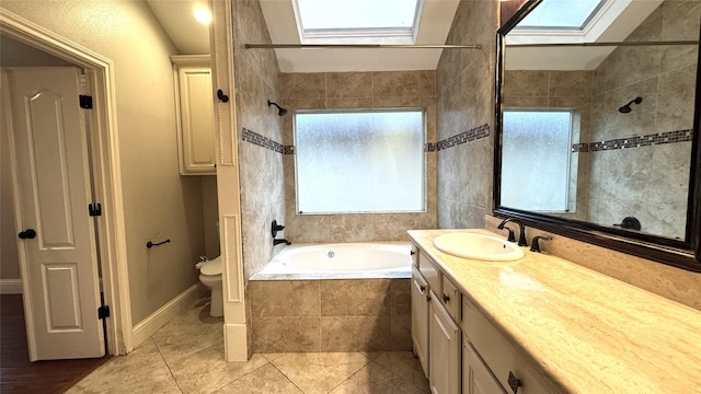 full bathroom with vanity, independent shower and bath, toilet, and vaulted ceiling with skylight