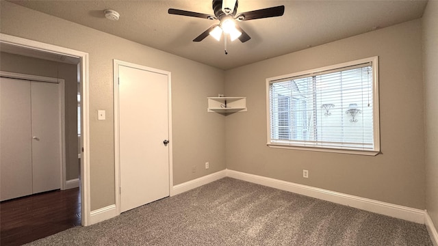 empty room featuring dark colored carpet and ceiling fan