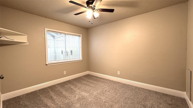 carpeted empty room featuring ceiling fan and a textured ceiling