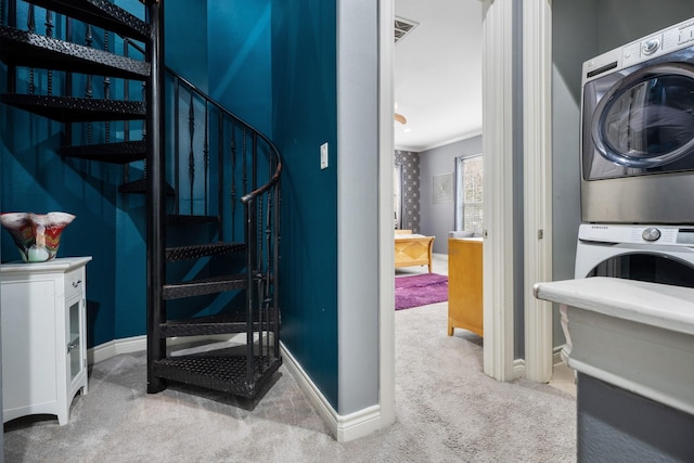 staircase featuring stacked washer and dryer, crown molding, and carpet floors