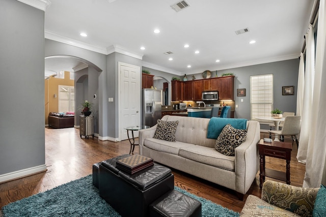 living room featuring ornamental molding and dark wood-type flooring