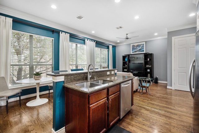 kitchen featuring sink, hardwood / wood-style flooring, dishwasher, a kitchen island with sink, and ornamental molding