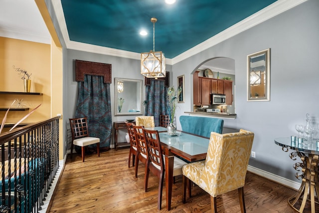 dining space featuring ornamental molding and hardwood / wood-style floors