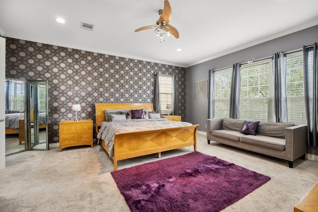 carpeted bedroom featuring crown molding and ceiling fan