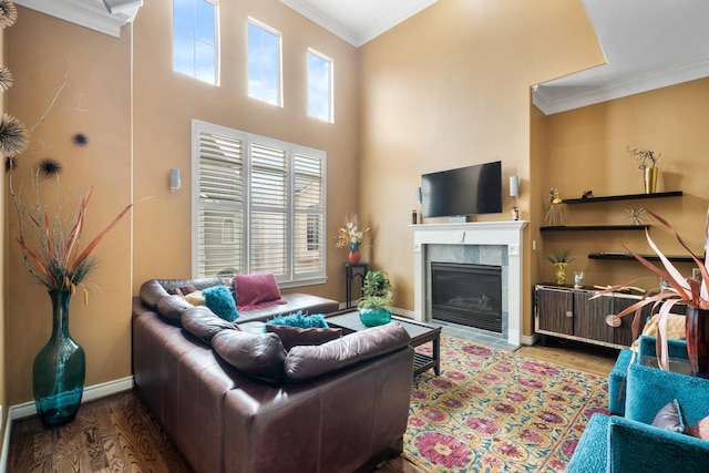 living room with ornamental molding, hardwood / wood-style floors, and a tile fireplace