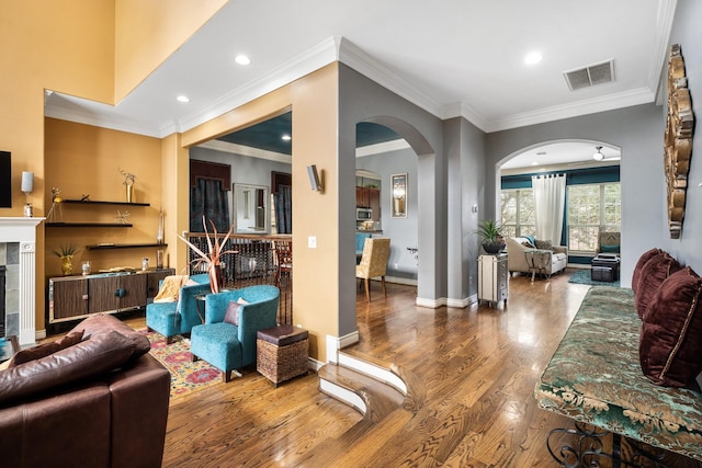 living room featuring crown molding, hardwood / wood-style floors, and a fireplace