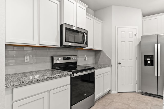 kitchen featuring tasteful backsplash, appliances with stainless steel finishes, light stone countertops, and white cabinets