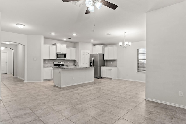 kitchen featuring white cabinetry, appliances with stainless steel finishes, a kitchen island with sink, and ceiling fan with notable chandelier