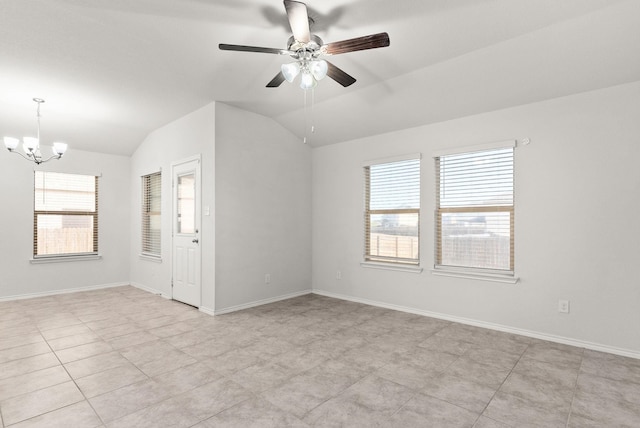 empty room featuring lofted ceiling and ceiling fan with notable chandelier