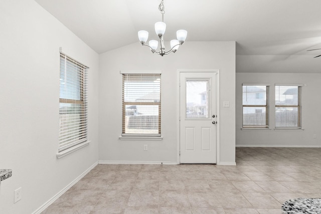 tiled foyer entrance with ceiling fan with notable chandelier and vaulted ceiling