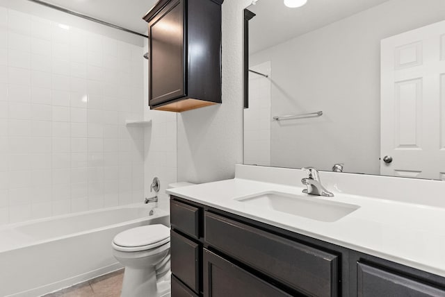 full bathroom featuring tiled shower / bath, vanity, toilet, and tile patterned floors