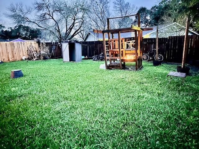 view of yard with a storage unit and a playground