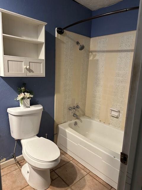 bathroom featuring tiled shower / bath combo, tile patterned floors, and toilet