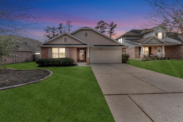 craftsman-style home featuring a garage and a lawn