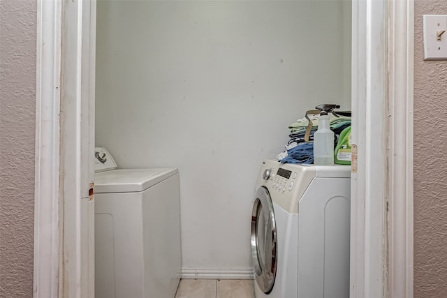 laundry area featuring light tile patterned floors and independent washer and dryer