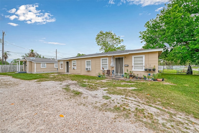 ranch-style home featuring cooling unit and a front yard