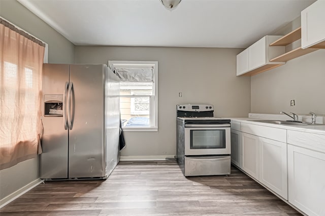 kitchen featuring white cabinetry, sink, light wood-type flooring, and appliances with stainless steel finishes