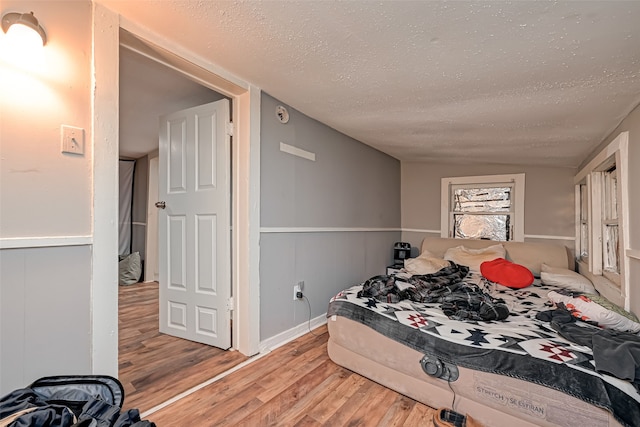 bedroom with wood-type flooring and a textured ceiling