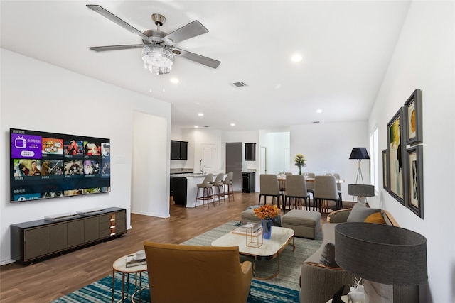 living room featuring dark hardwood / wood-style flooring, sink, and ceiling fan