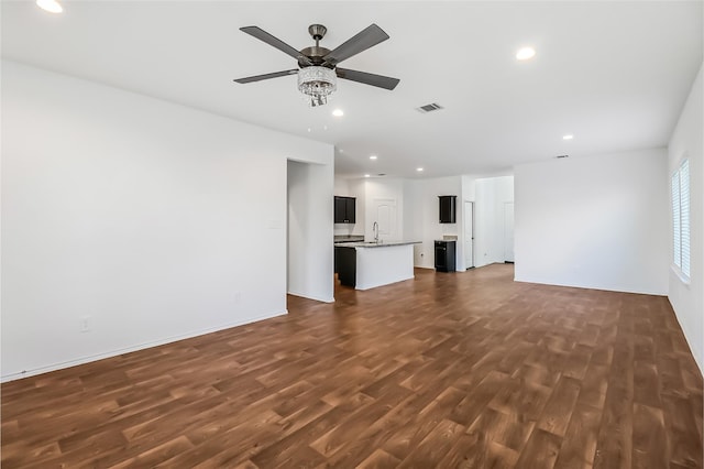 unfurnished living room featuring sink, dark hardwood / wood-style floors, and ceiling fan