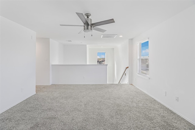 carpeted empty room featuring ceiling fan and a healthy amount of sunlight