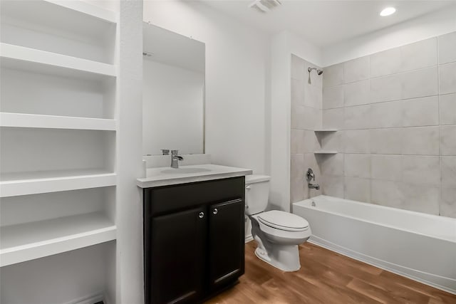 full bathroom with vanity, hardwood / wood-style flooring, toilet, and tiled shower / bath combo