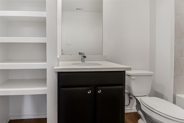 bathroom featuring vanity, wood-type flooring, and toilet