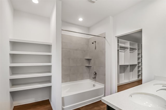 bathroom featuring hardwood / wood-style flooring, tiled shower / bath, and vanity