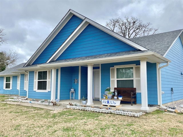 view of front of home featuring covered porch and a front yard